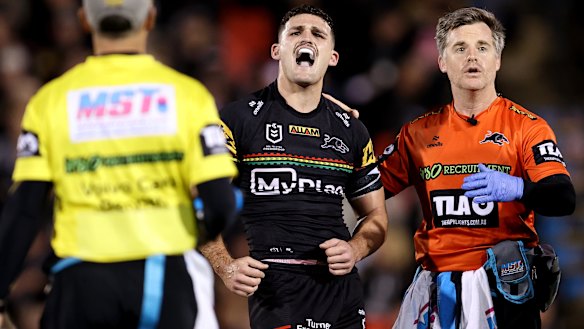 A frustrated Nathan Cleary is assisted from the field by Penrith chief physio Pete Green.