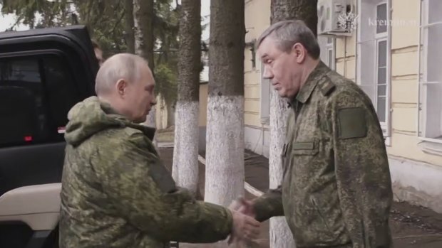 Vladimir Putin, left, shakes hands with Russian Chief of General Staff Gen. Valery Gerasimov while visiting military headquarters in the Kursk region of Russia.