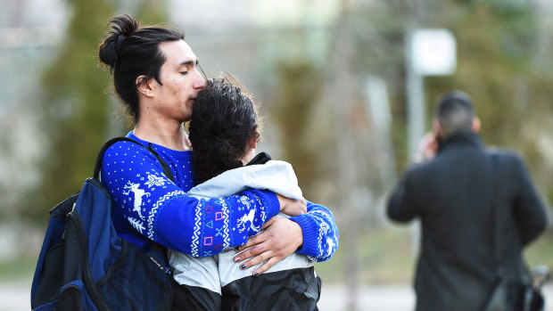 Two people comfort each other after a rented van plowed down a crowded sidewalk, killing multiple people in Toronto.