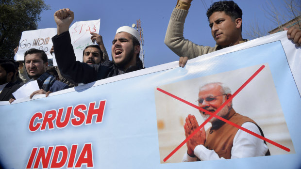 Pakistanis rally behind a banner showing Indian Prime Minister Narendra Modi in Peshawar on Wednesday.