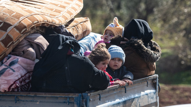 Displaced Syrian families ride in the back of a truck loaded with the family's possessions towards the Turkish border on Thursday.