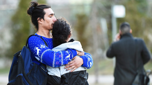Two people comfort each other after a rented van plowed down a crowded sidewalk, killing multiple people in Toronto.