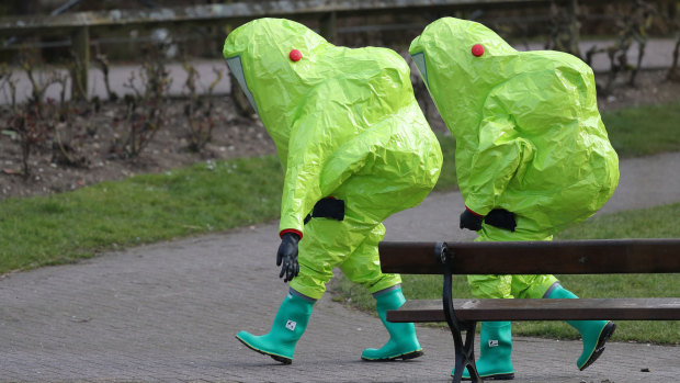 Personnel in hazmat suits walk away after securing the covering on a bench in the Maltings shopping centre where former Russian double agent Sergei Skripal and his daughter Yulia were found critically ill.