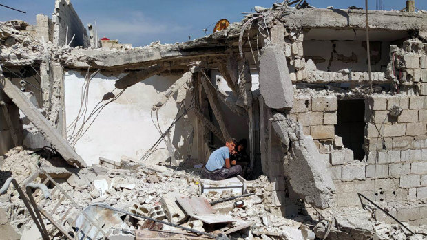 Boys sit amid the rubble of a house that, according to the Syrian authorities, was attacked by an Israeli air strike in Damascus in April.