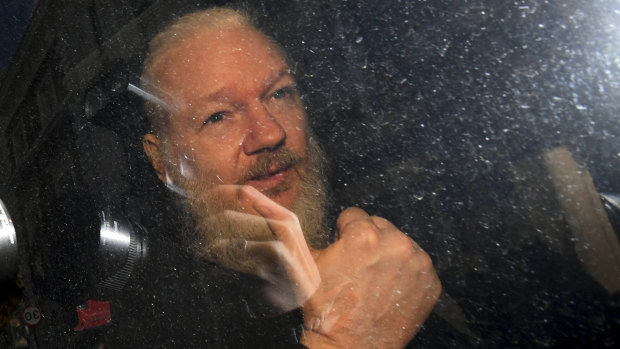 Julian Assange gestures as he arrives at Westminster Magistrates' Court in London.