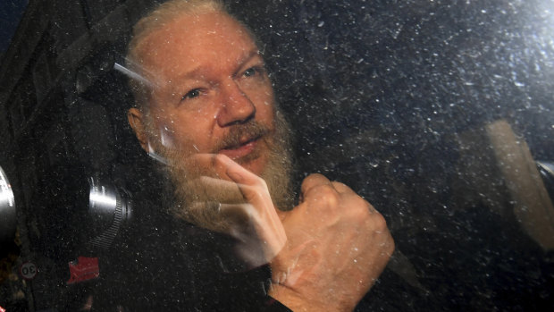 Julian Assange gestures as he arrives at Westminster Magistrates' Court in London.