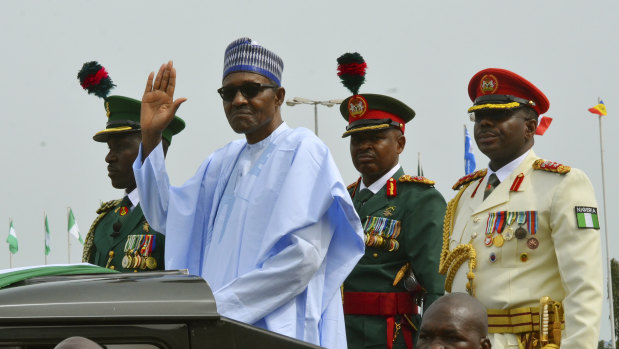 Nigerian President Muhammadu Buhari waves to the crowd during the 58th anniversary celebrations of Nigerian independence in Abuja on October 1.