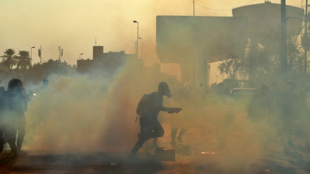 Security forces fire tear-gas in Baghdad. They also used live rounds, wounding over a dozen protesters.