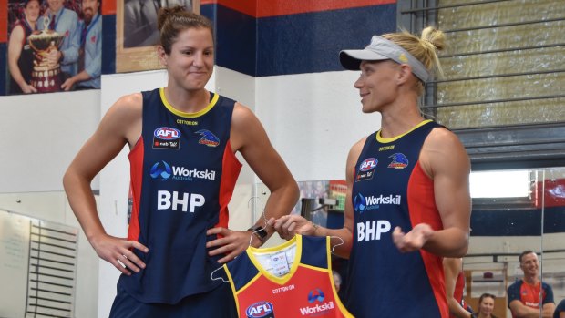 Jess Foley (centre) is presented with her Adelaide Crows jumper by teammate Erin Phillips (right).