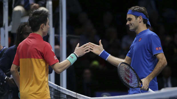 Give him a hand: Kei Nishikori shakes hands with Roger Federer after Nishikori beat his idol.