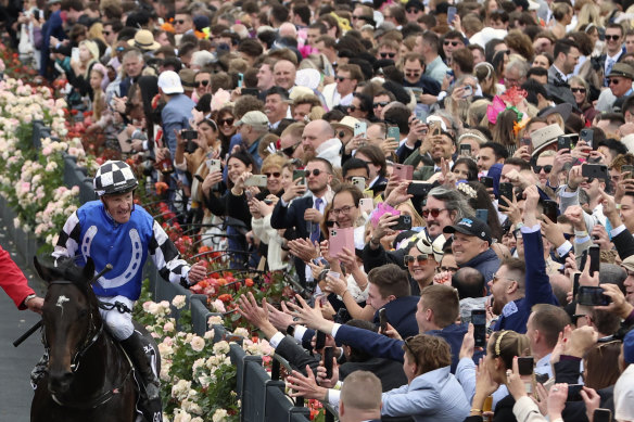 Gold Trip ridden by jockey Mark Zahra trots past the crowd after winning the Melbourne Cup.