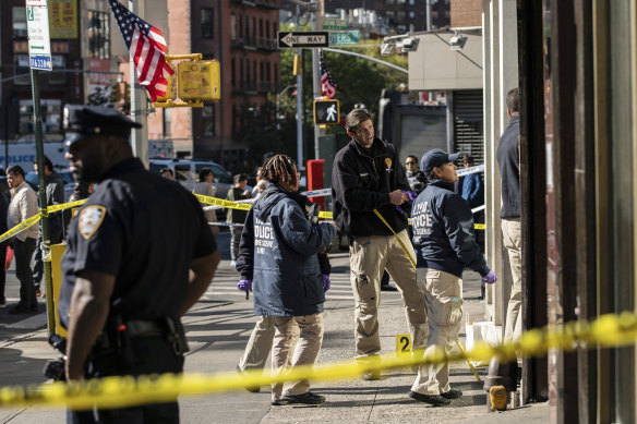 New York Police Department officers investigate the scene of one of the attacks in Manhattan's Chinatown.