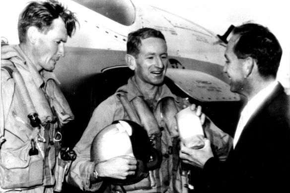 A representative of the John Curtin School of Medicine hands the package of drugs to pilot J. Perret. At left is the plane’s navigator, Flight-Lieutenant C. Whitely.