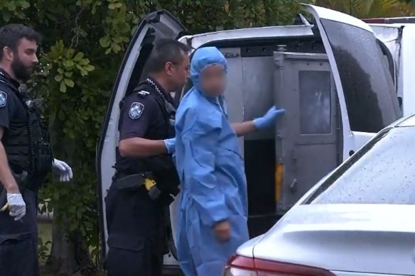 Officers lead a suspect into a police van after North Lakes mother Emma Lovell died of her injuries on Boxing Day.