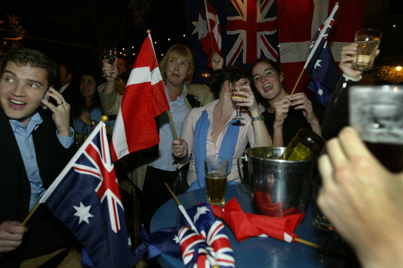 Danish and Australian flags are waved as crowds gathered in the beer garden of the Slip Inn on Sussex St, 
Sydney, celebrating the Royal wedding of Mary Donaldson and Danish Prince Frederick. The Royal couple met 
at the Slip Inn during the 2000 Olympic Games. 14 May, 2004.