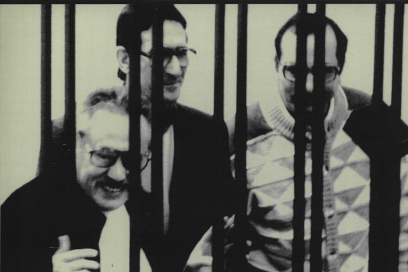 Luciano Leggio (left), the reputed "boss of bosses" of Italian Cosa Nostra, smiles from behind the bars during he big mafia trials in Sicily in 1986. 