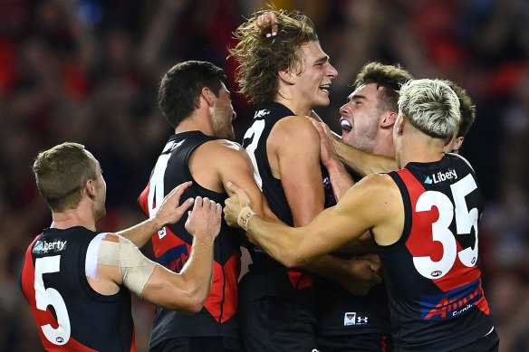 Harrison Jones is congratulated by team mates after kicking a goal during the round three match between the Bombers and St Kilda at Marvel Stadium.