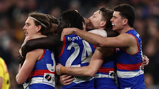 Jubilation: The Bulldogs celebrate their narrow win over Collingwood in the AFL’s inaugural wildcard final.