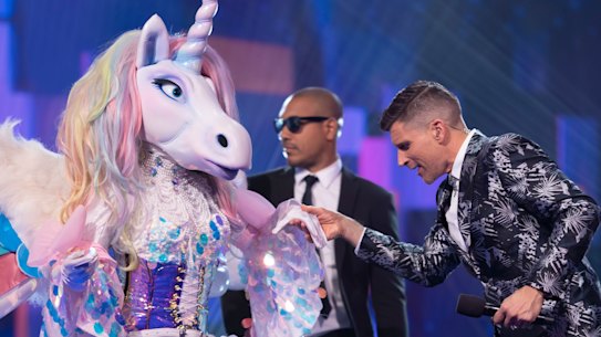 The Masked Singer contestant Unicorn with the show's host Osher Günsberg. 