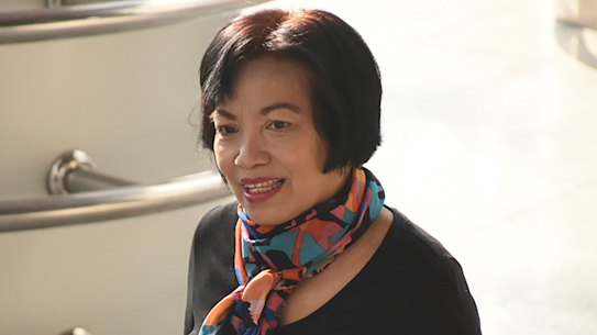 The former civil servant identified only by her first name Anchan, right, shakes hands with a friend as she arrives at Bangkok Criminal Court. 