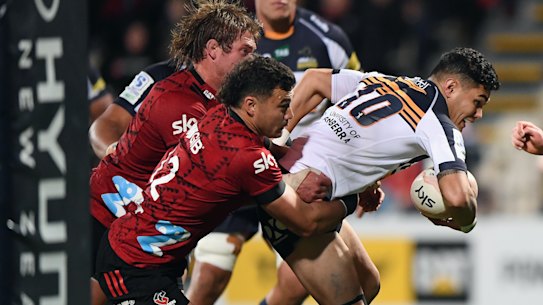 Noah Lolesio of the Brumbies is tackled by David Havili at Orangetheory Stadium in Christchurch. 