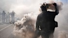 A protester throws a smoke canister on the 101 Freeway near the metropolitan detention centre of downtown Los Angeles.