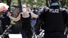 A protester in Seattle holds out her arms as she talks with police. 