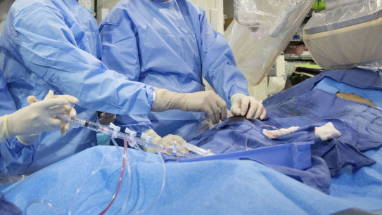 Doctors perform an angioplasty. Through a blood vessel in the groin, a tube is guided to a blockage in the heart. A tiny balloon is then inflated to flatten the clog, and a mesh tube called a stent is inserted to prop the artery open. 