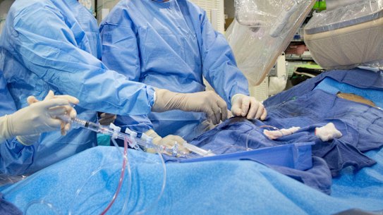 Doctors perform an angioplasty. Through a blood vessel in the groin, a tube is guided to a blockage in the heart. A tiny balloon is then inflated to flatten the clog, and a mesh tube called a stent is inserted to prop the artery open. 