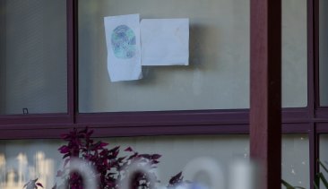 A child's drawing in the window of the Perinovic's home.