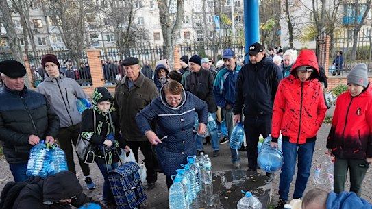 People fill containers with water from public water pumps in Kyiv.