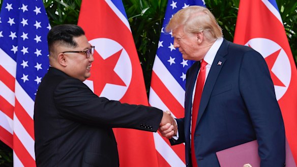 "In love": North Korea leader Kim Jong-un and US President Donald Trump shake hands at the conclusion of their meetings in Singapore in June. 