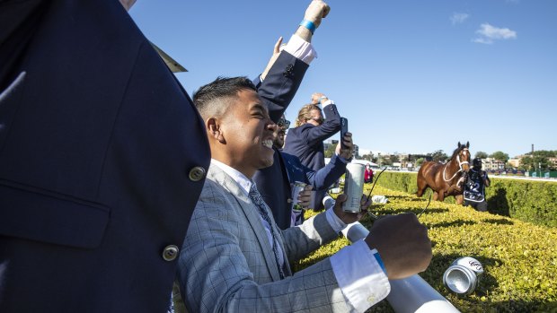 Punters celebrate as horses return to their raceday stalls after The Everest.