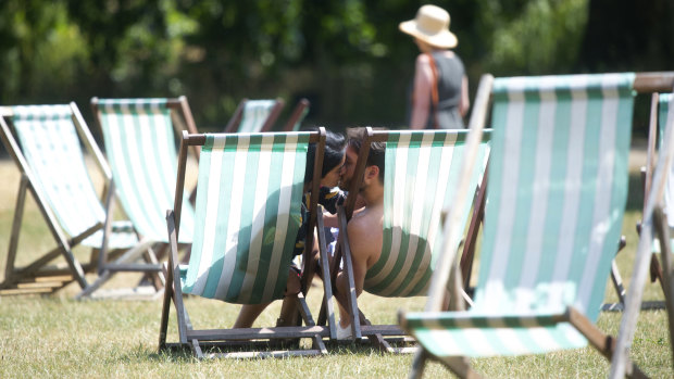 A couple kiss in London's Green Park as they take advantage of the warm weather. 