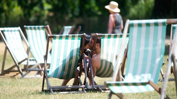 A couple kiss in London's Green Park as they take advantage of the warm weather. 