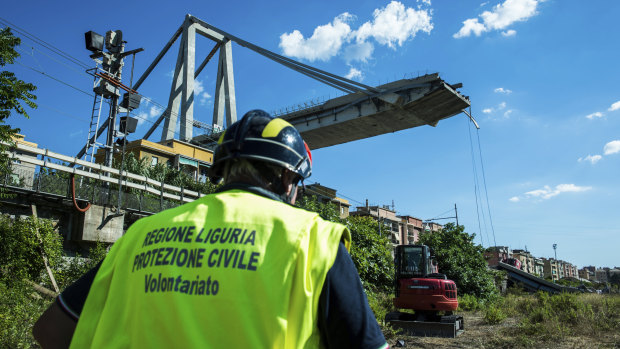 A worker inspects the the area around the collapsed Morandi highway bridge, in Genoa.