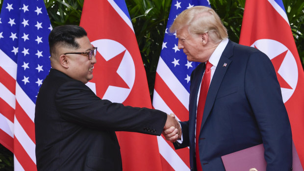 "In love": North Korea leader Kim Jong-un and US President Donald Trump shake hands at the conclusion of their meetings in Singapore in June. 