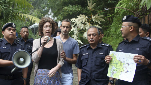 Meabh Quoirin, second left, the mother of a missing British girl Nora Anne Quoirin, speaks to police officers as father Sebastien Quoirin, centre, stands beside her, in Seremban, Negeri Sembilan, Malaysia.