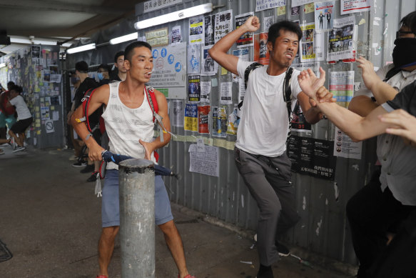 Pro-China supporters, in white, fight with pro-democracy protesters at the Kowloon Bay district in Hong Kong on Saturday.