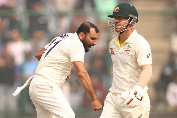 Mohammed Shami celebrates taking the wicket of David Warner.