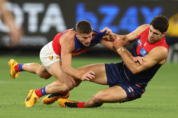 Christian Petracca lays a tackle on Dayne Zorko.