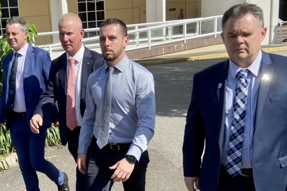 Rolfe leaving court flanked by NT Police Association president Paul McCue (right) and Police Federation of Australia president Ian Leavers (second from left).