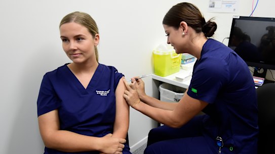 Registered nurse Rebecca DeJong receives a dose of the Pfizer COVID-19 vaccination at the Townsville University Hospital hub in March.