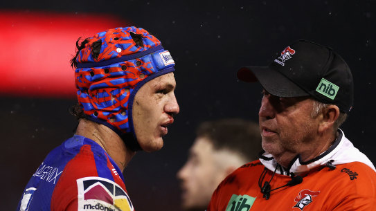 Knights fullback Kalyn Ponga is examined by the trainer after suffering a head knock.
