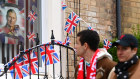 Not for everyone. Football fans walk past a house in Liverpool decorated for this weekend’s coronation.