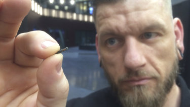 Self-described “body hacker” Jowan Osterlund from Biohax Sweden, holds a small microchip implant, similar to those implanted into workers in Sweden.