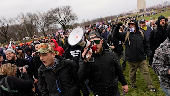 Ethan Nordean, with backward baseball hat and bullhorn, leads members of the far-right group Proud Boys in marching before the riot at the US Capitol. 