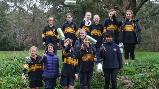 Bentleigh West Primary students, with Dr Kavitha Chinathamby from RMIT, front right, throw GPS-tracked bottles into Dandenong Creek as part of the Litter Trackers program.