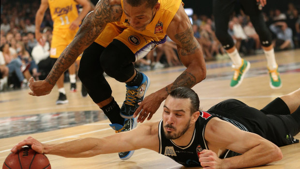 Flat out: Melbourne's Chris Goulding dives after the ball under pressure from Sydney's Jerome Randle.