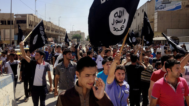 Islamic State supporters carry al-Qaeda flags in Mosul in 2014.